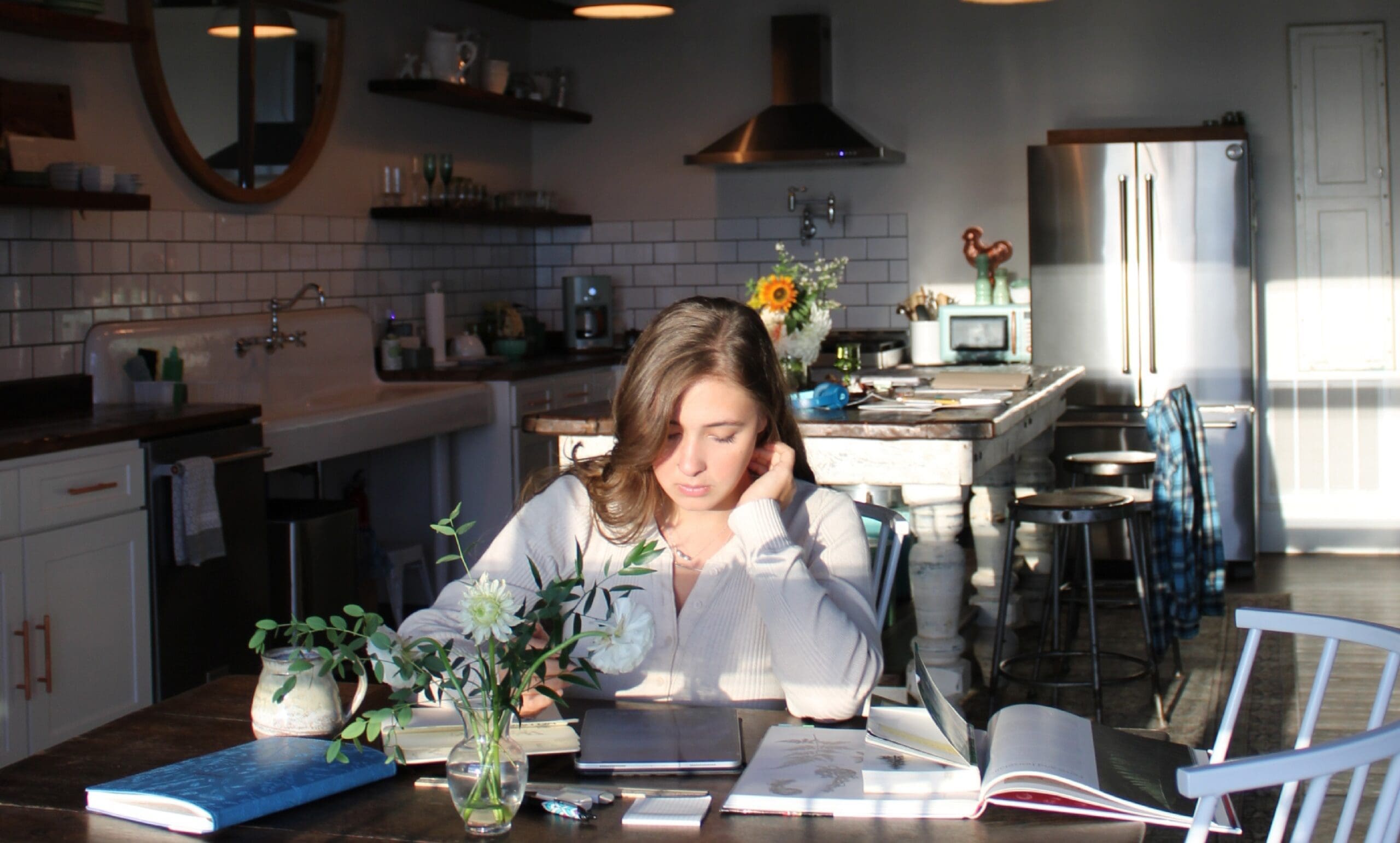 Catie Cedar June Studio working on her own brand at a table in the kitchen